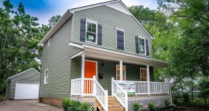 Two-story home with green vinyl siding