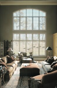 Picture of luxurious sitting room with dawn light streaming through two story windows
