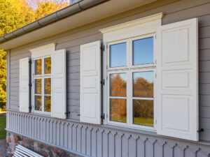 White wooden windows with shutters in a renovated wooden house