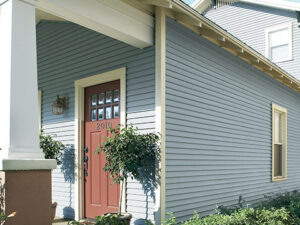 Side of house with baby blue siding and attractive terracotta entry door